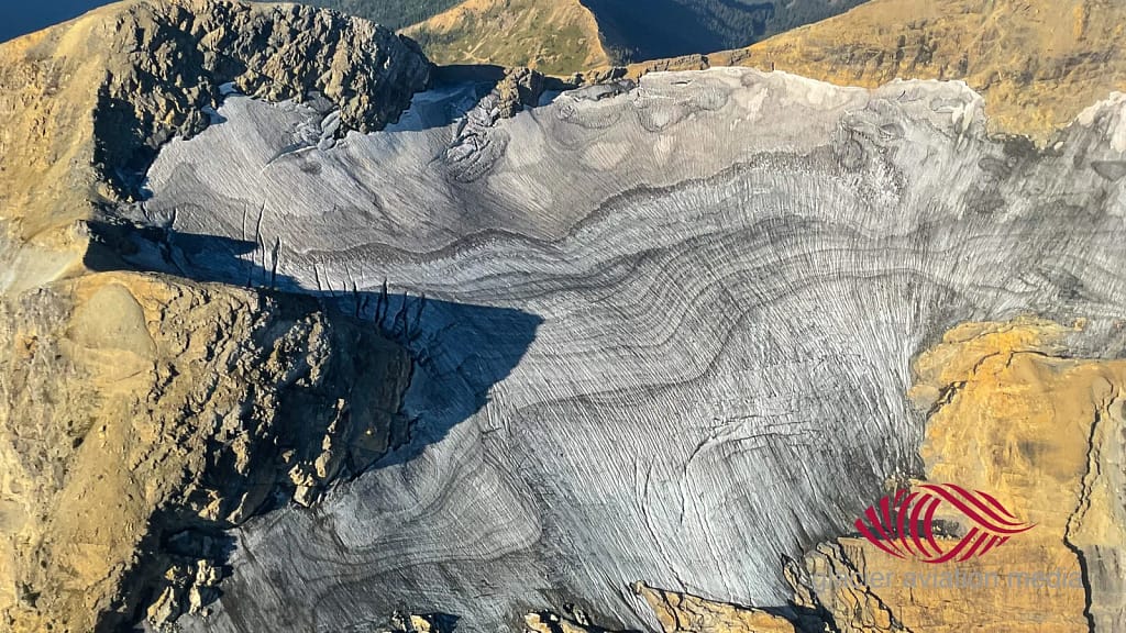 Close-up aerial of Grant Glacier in Glacier National Park, captured during a helicopter tour with Glacier Aviation Services